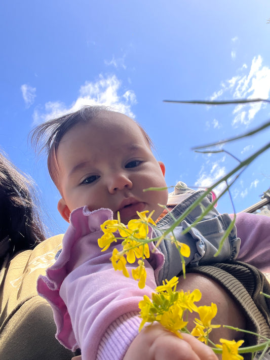 Cute baby in garden holding flowers - health benefits